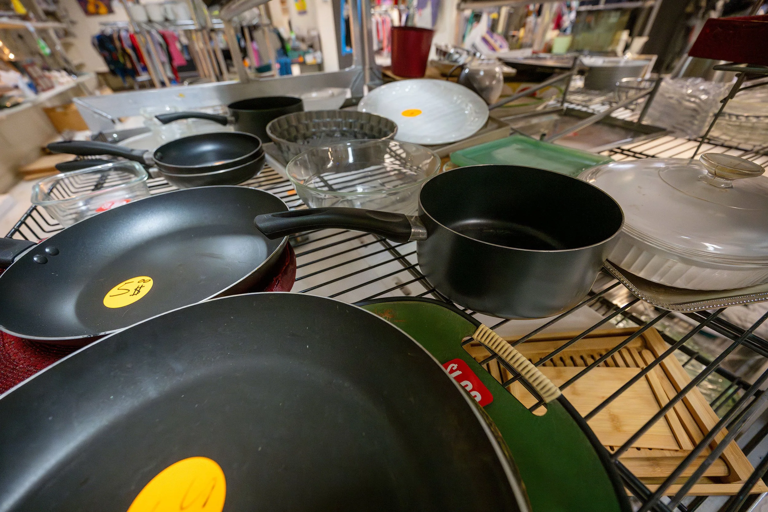 Assorted pots, pans, and dishes on a store display table.