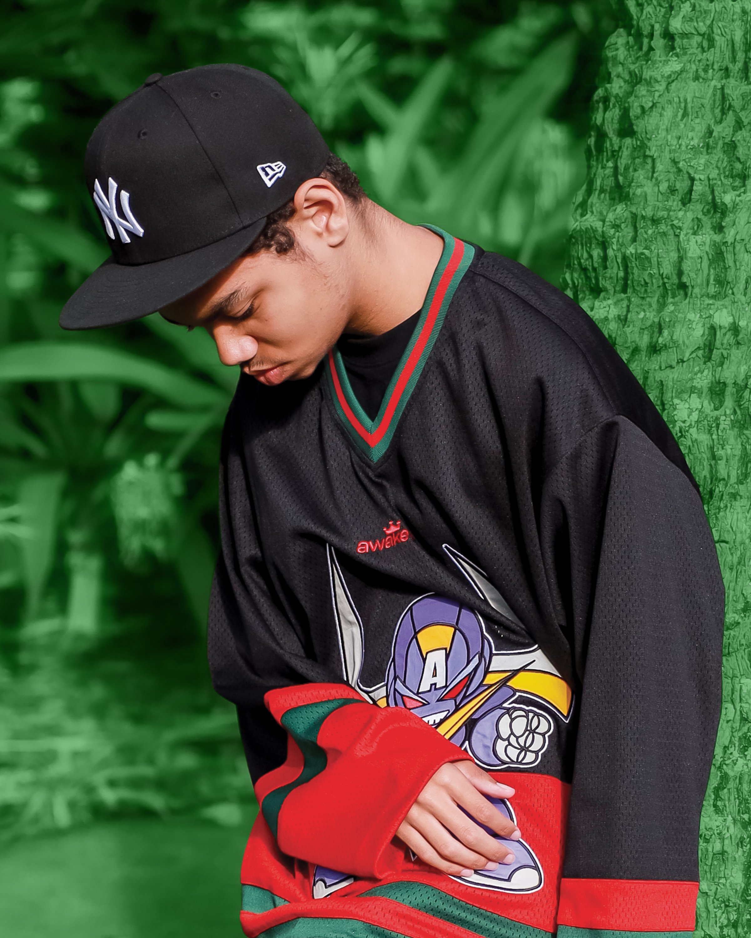 Farber wearing a baseball cap and black jersey with cartoon graphic in outdoor setting.