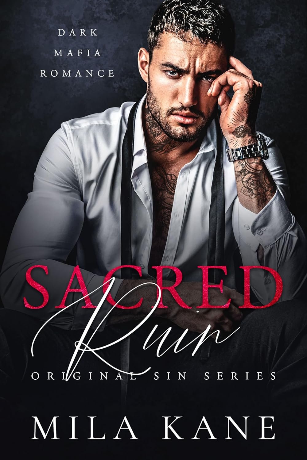 Book cover for "Sacred Ruin" by Mila Kane, featuring a serious-looking man with tattoos, a white shirt, and a watch, sitting against a dark background.