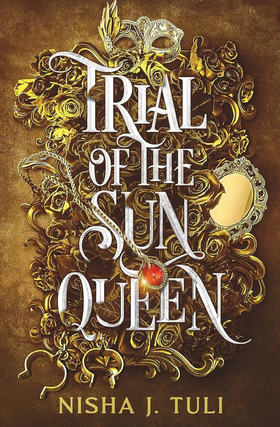 Book cover titled 'Trial of the Sun Queen' by Nisha J. Tuli. The cover features a background of gold roses, a masquerade mask, and a necklace with a red gemstone pendant.