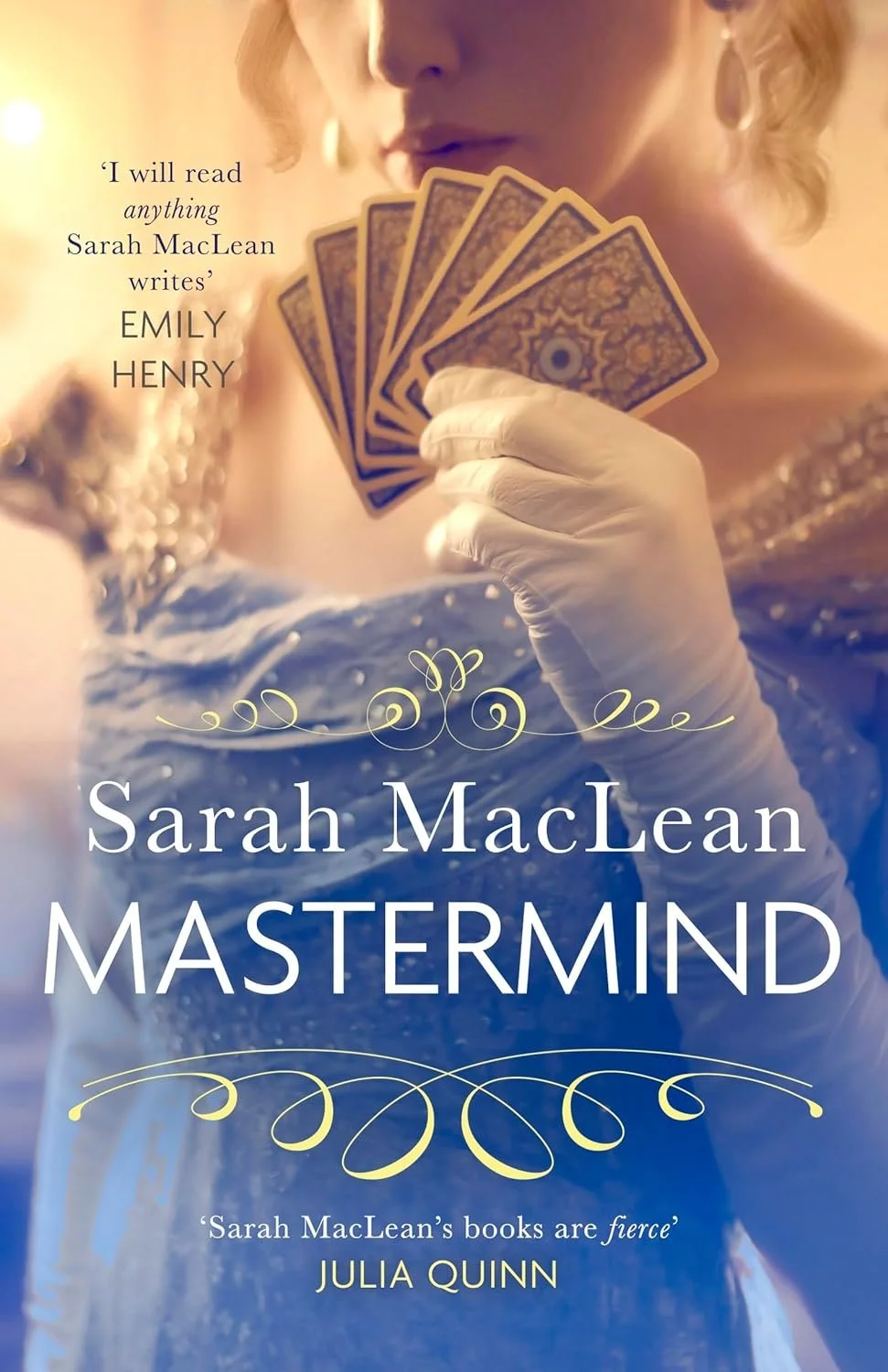 The cover of the book 'Mastermind' by Sarah MacLean features a woman in a vintage dress holding a fan of tarot cards, with a blurred background.