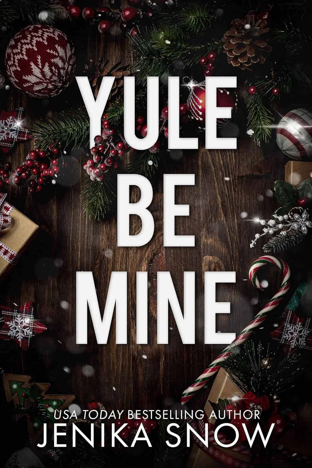 Christmas-themed book cover with decorations like ornaments, pine branches, berries, and candy canes. The title is 'Yule Be Mine' and the author is Jenika Snow.