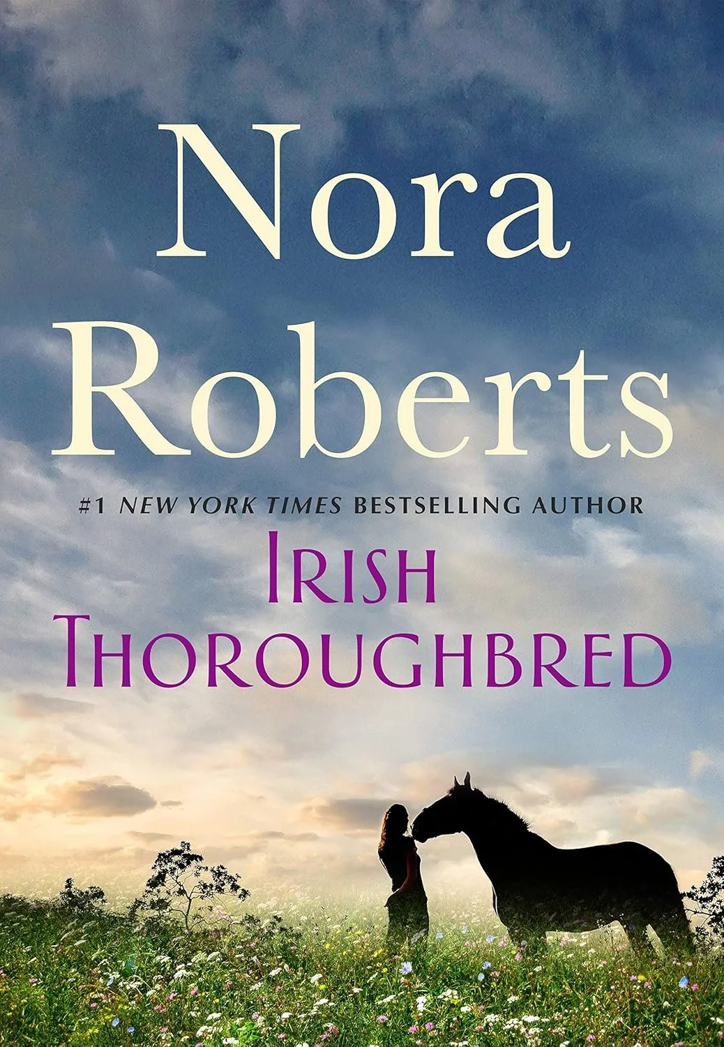 Book cover for 'Irish Thoroughbred' by Nora Roberts, featuring a girl and a horse in a grassy field at sunset with a cloudy sky.