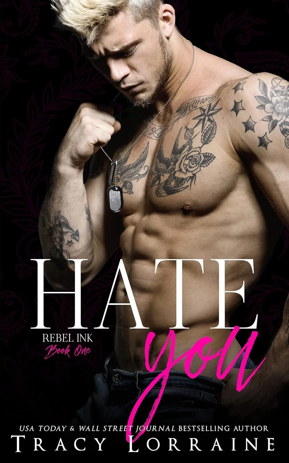 Book cover featuring a shirtless man with tattoos, holding a dog tag necklace, with the title 'Hate You' and the subtitle 'Rebel Ink Book One' by Tracy Loraine.