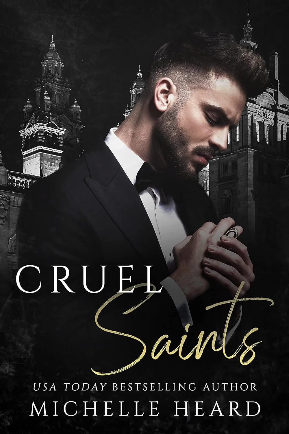Book cover titled 'Cruel Saints' by Michelle Heard. Features a young man in a tuxedo with hands clasped, head bowed, in front of a dark cityscape with historic buildings.