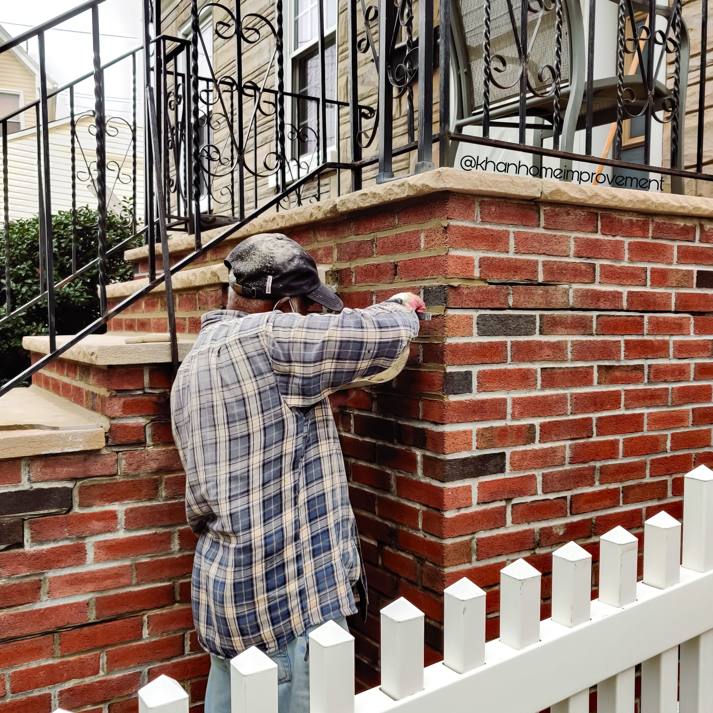 A professional brick pointing contractor repairing a brick wall under Khan Home Improvement’s masonry services.