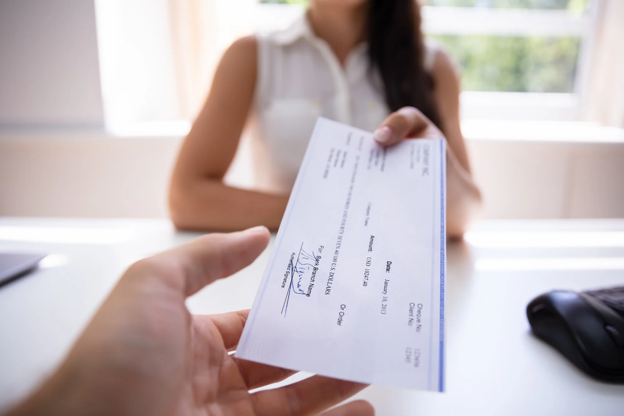 Woman Handing Over Cheque