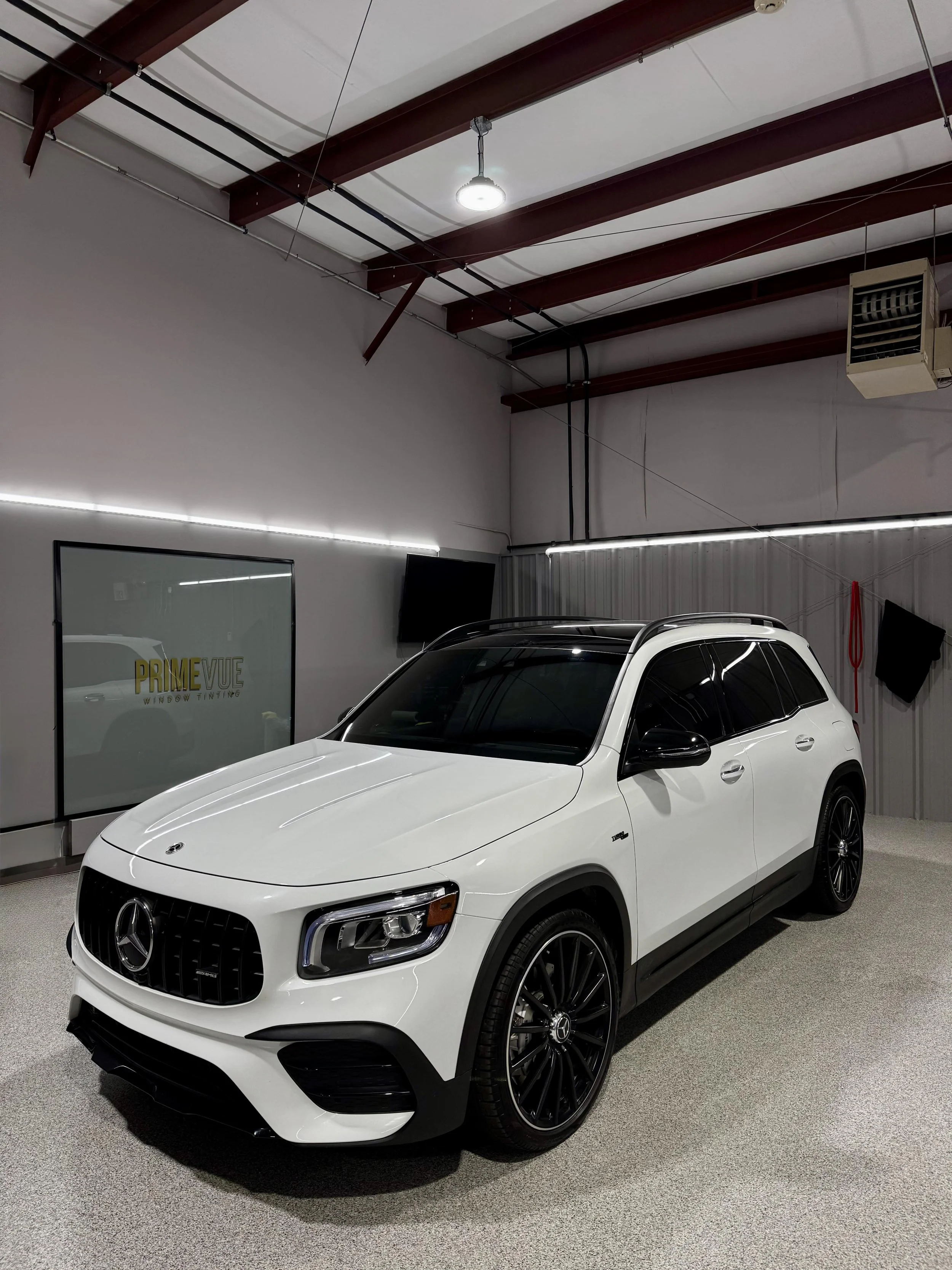 A white Mercedes-Benz SUV parked inside a clean, modern showroom at PrimeVue in Plainfield.