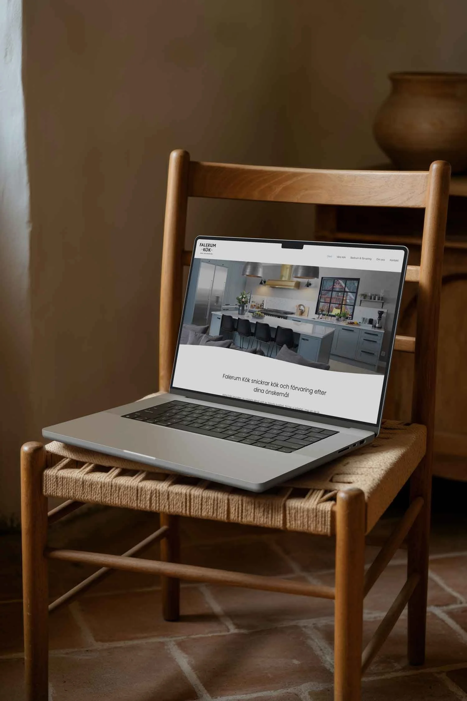 Mac på en stol med Falerum webbplats. Therese Squarespace webbdesign.