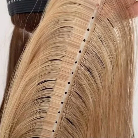 Close-up of a hair auditioning strip with blonde hair attached for color testing.