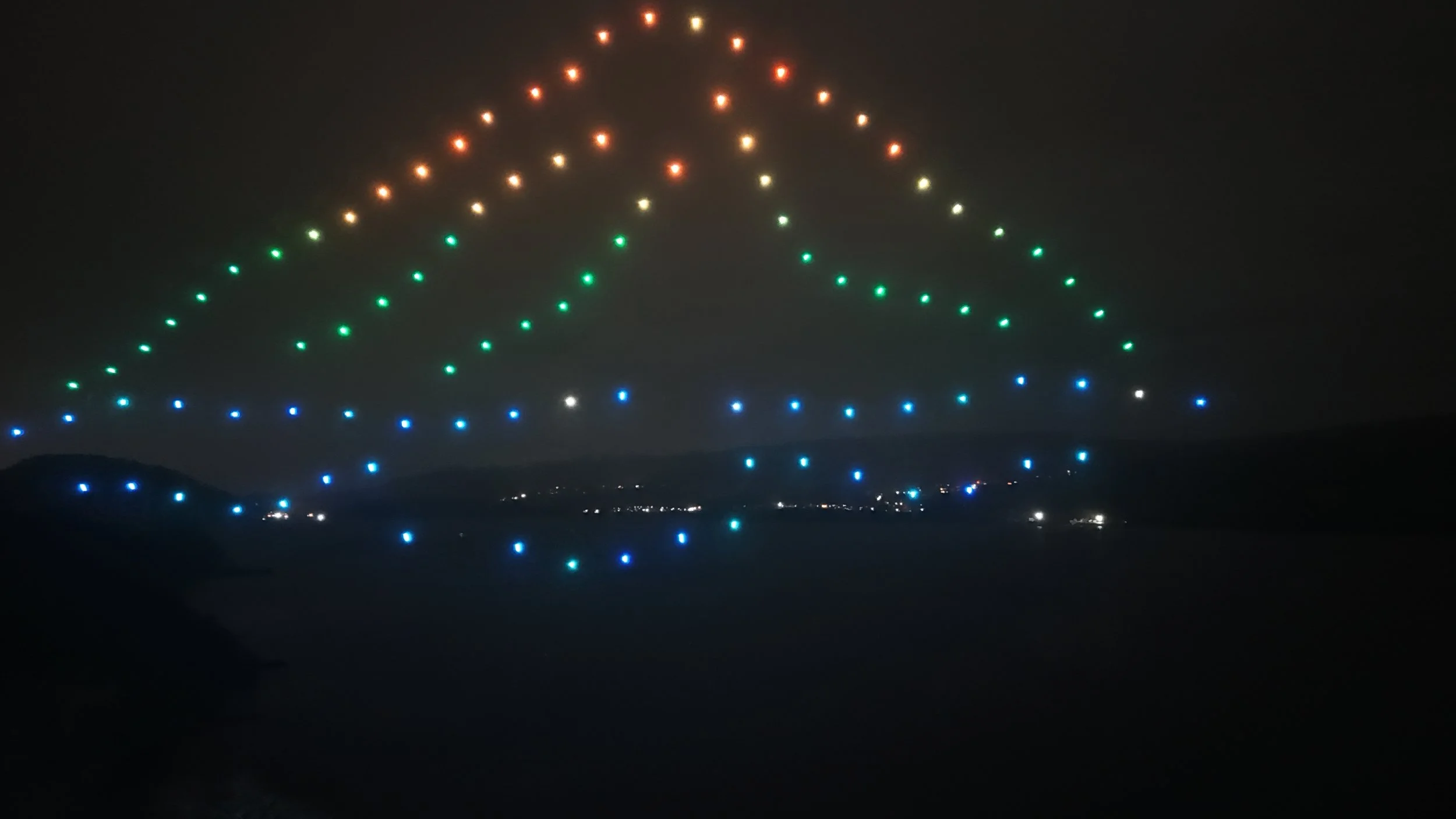 Nighttime view of a large airport runway with lights arranged in a pattern resembling a Christmas tree.