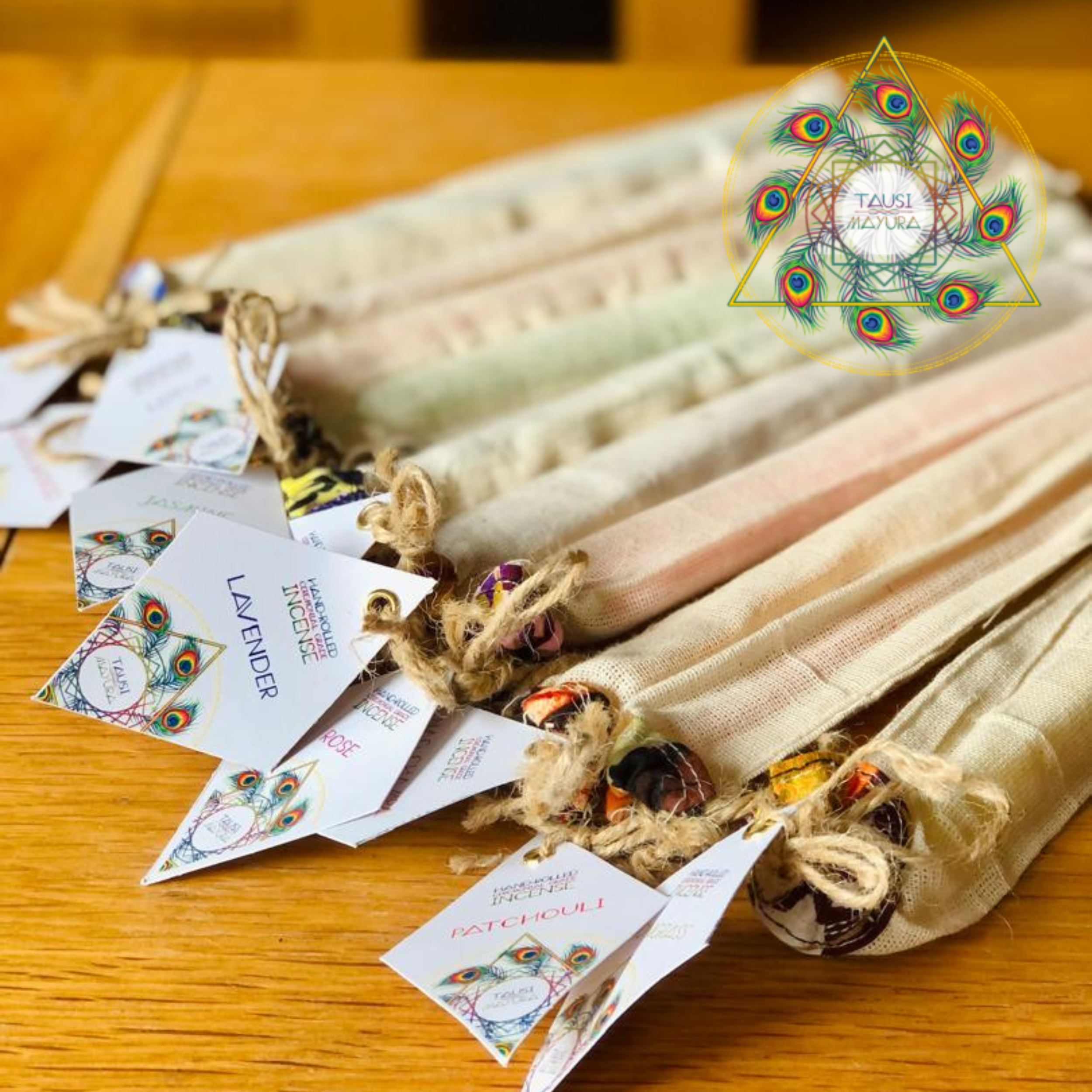 A display of fabric samples with attached tags featuring peacock feather designs and the words 'Handmade Incense'.