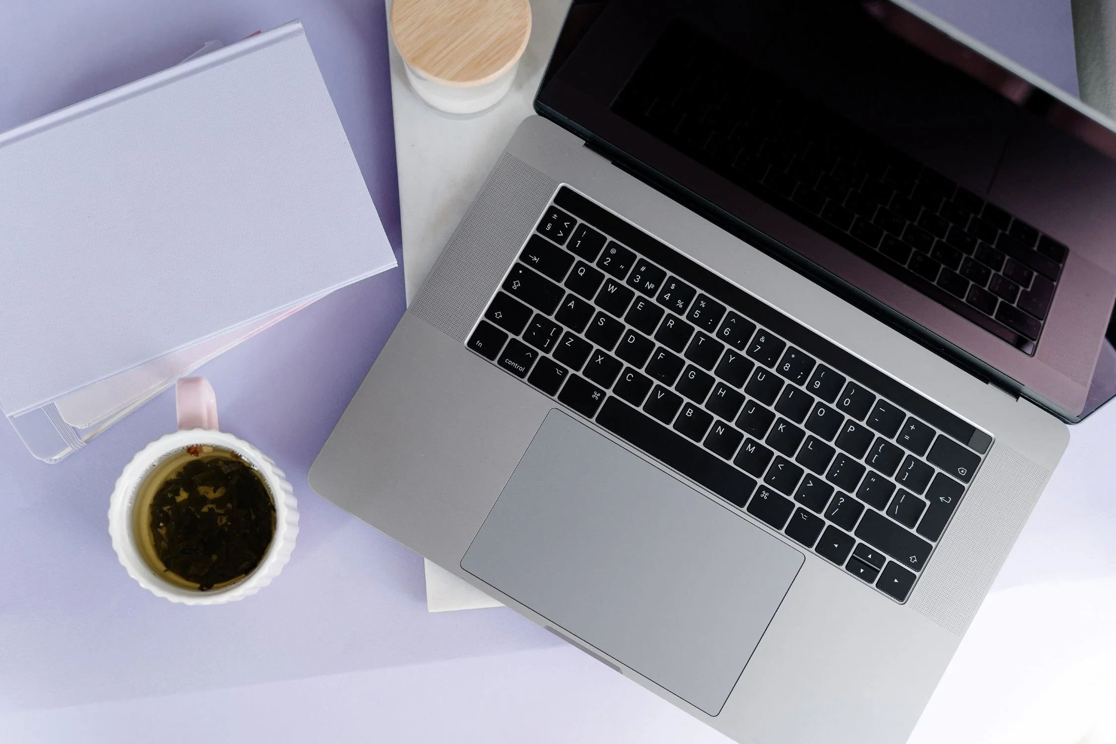 A desk with a laptop in a purple workspace
