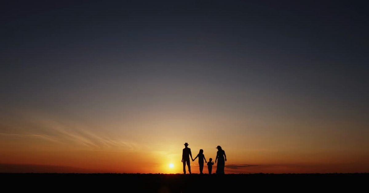 Family in silhouette against a setting sun.png