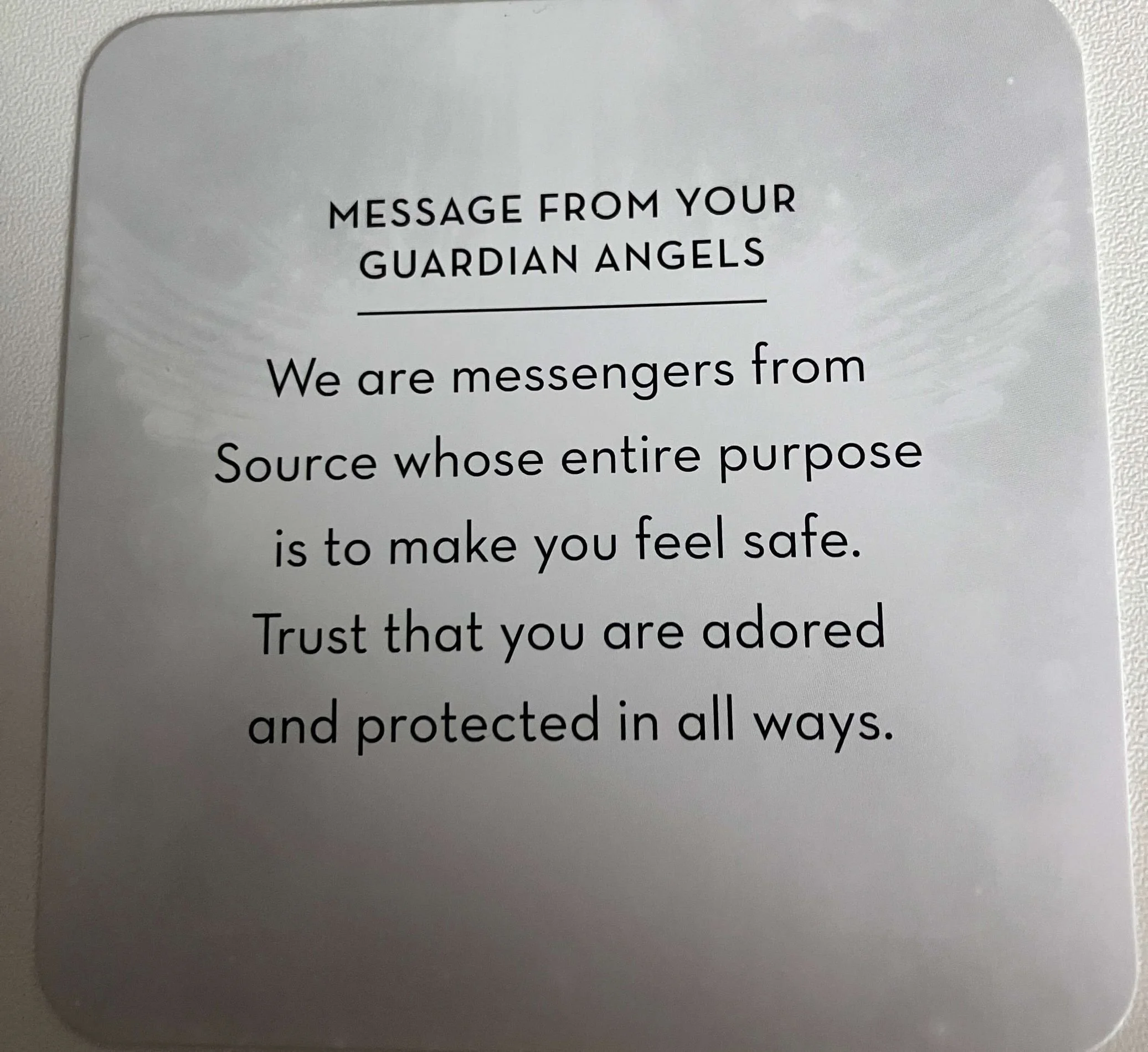 A card with a message from guardian angels, stating they are messengers from a source that aims to make you feel safe, adored, and protected.