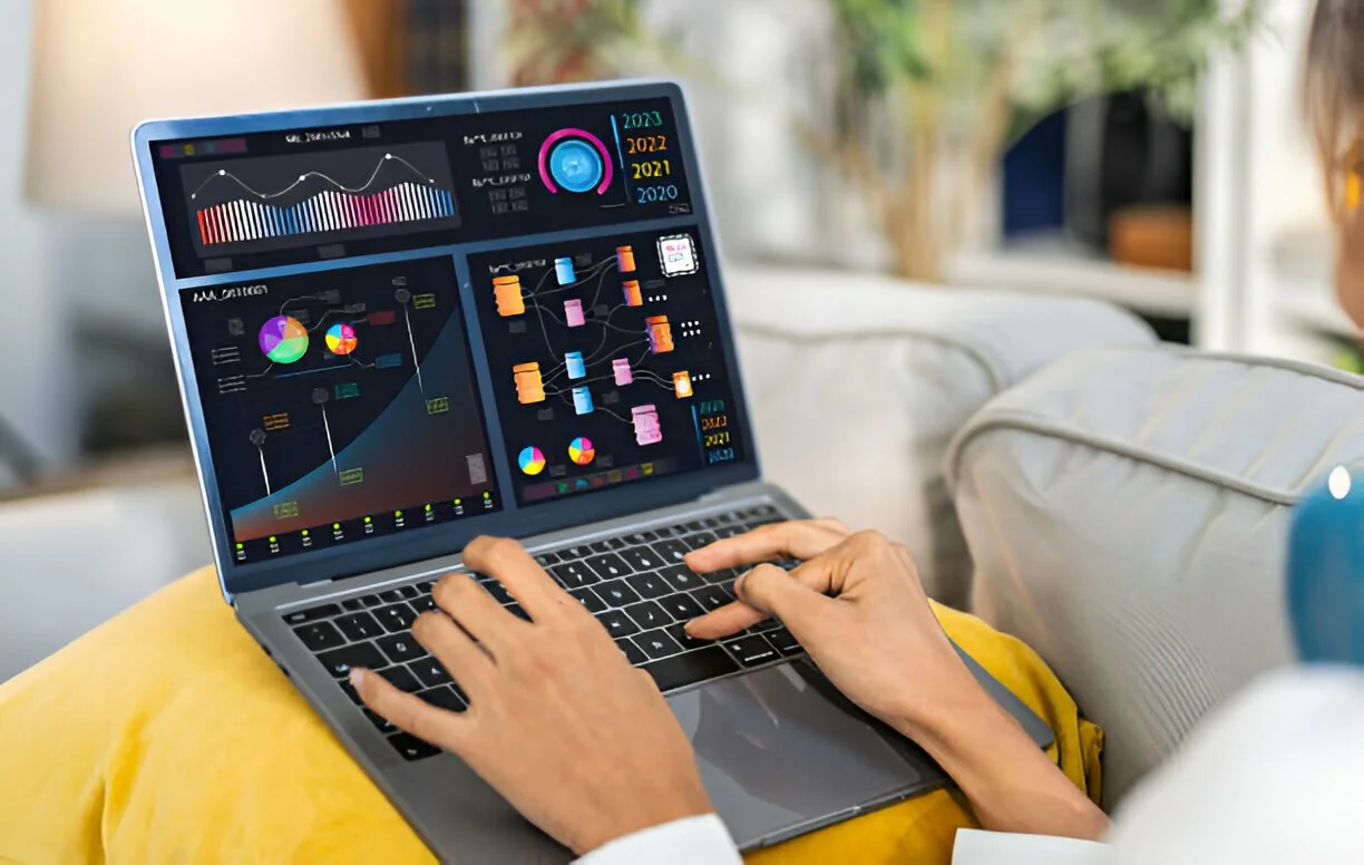 Person using a laptop displaying colorful charts and graphs