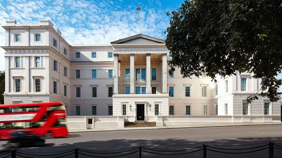 The White House, the official residence and workplace of the President of the United States, viewed from the street with a red bus passing by.