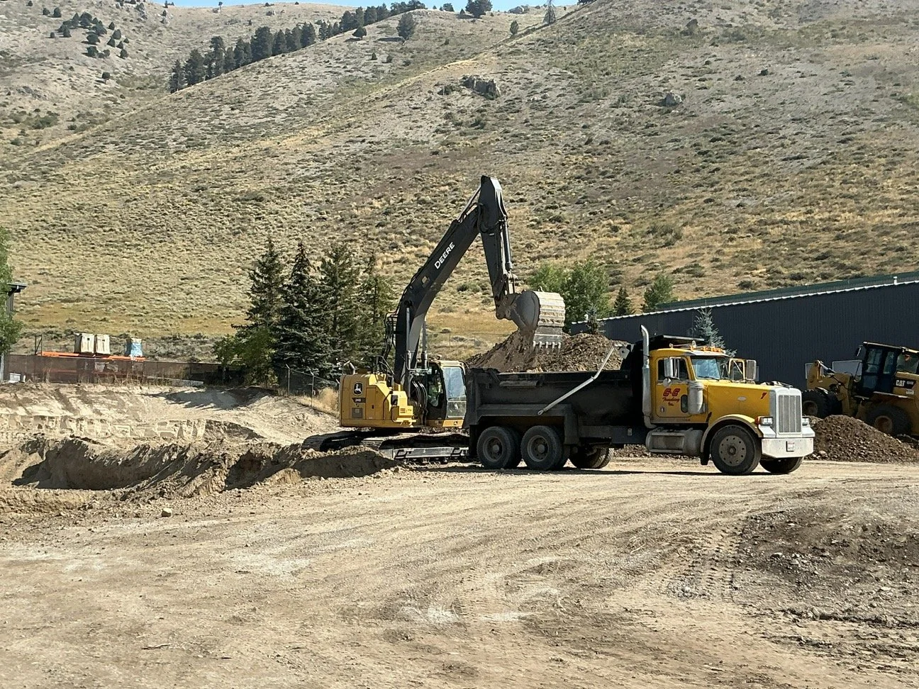 FH Wyoming project site. Dump truck with heavy equipment doing earthwork.
