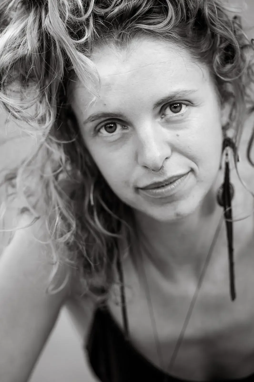 Verena Franzetti, photo en noir et blanc cheveux en vrac portant des boucle d'oreilles longues