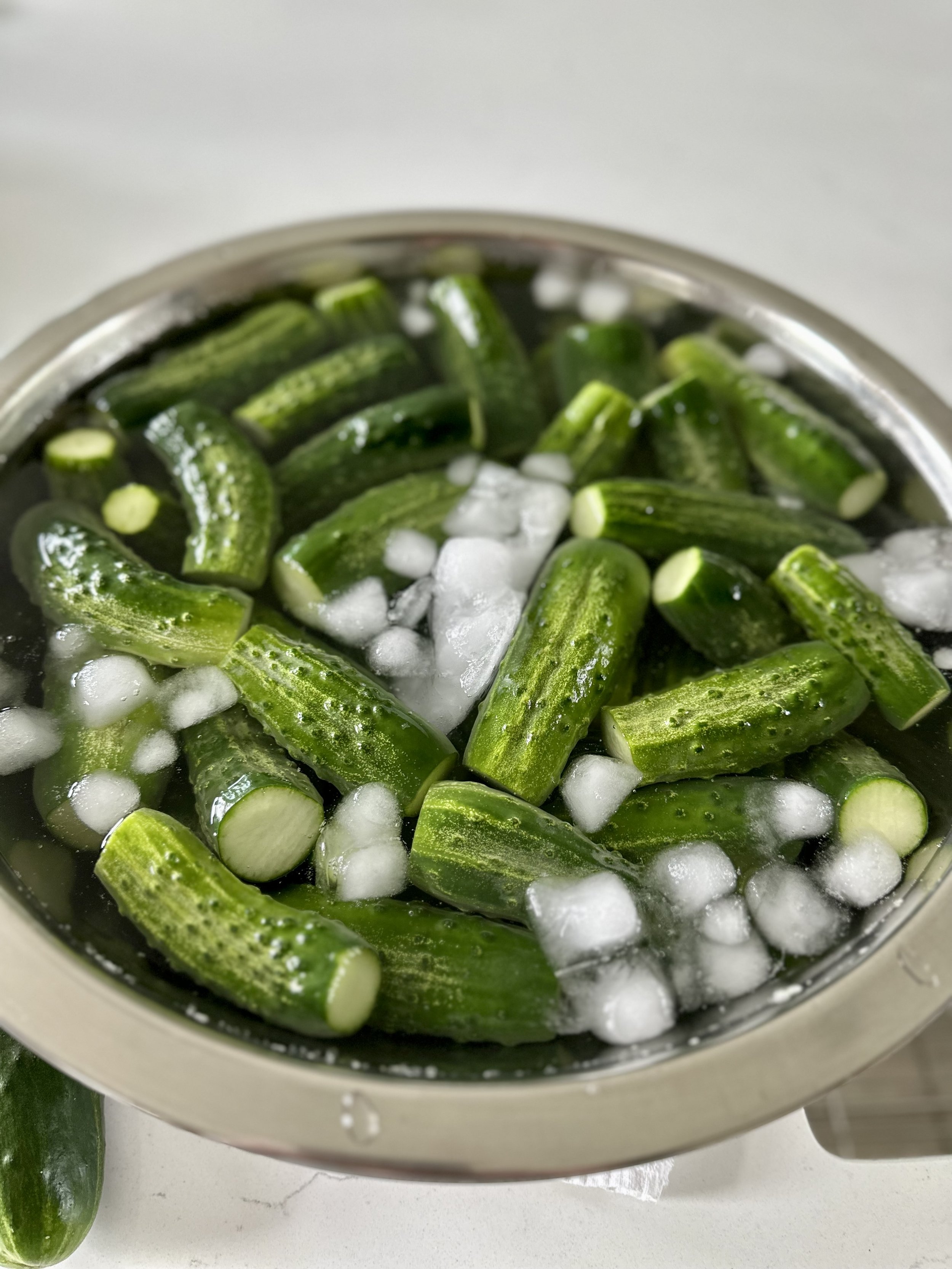 Fresh cucumbers in a bowl of ice water