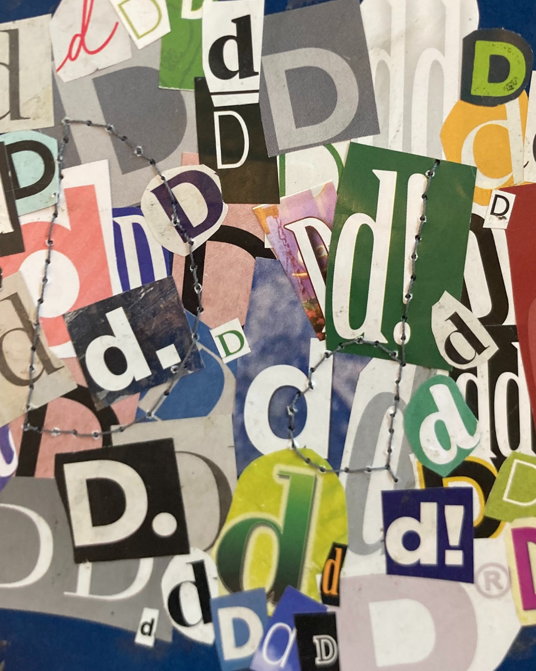 a collage of the letter d taken from various magazines. the letter D capitalized and lower case are stitched over