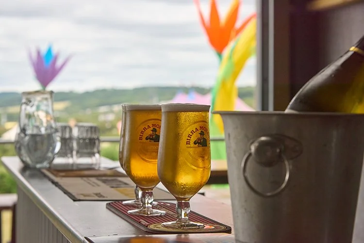 Two glasses of Birra Moretti beer on a bar counter at Festivue with a view of the pyramid stage