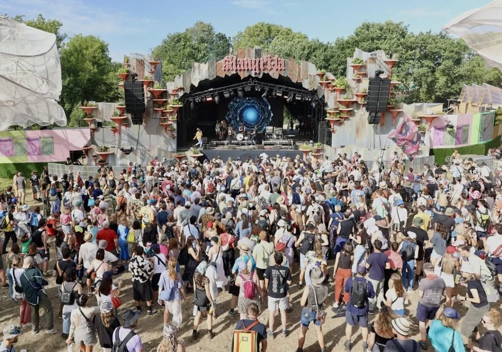 Festival crowd enjoying live music near our boutique glamping village