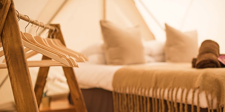 Luxury Super Bell tent with soft furnishings inside boutique glamping village