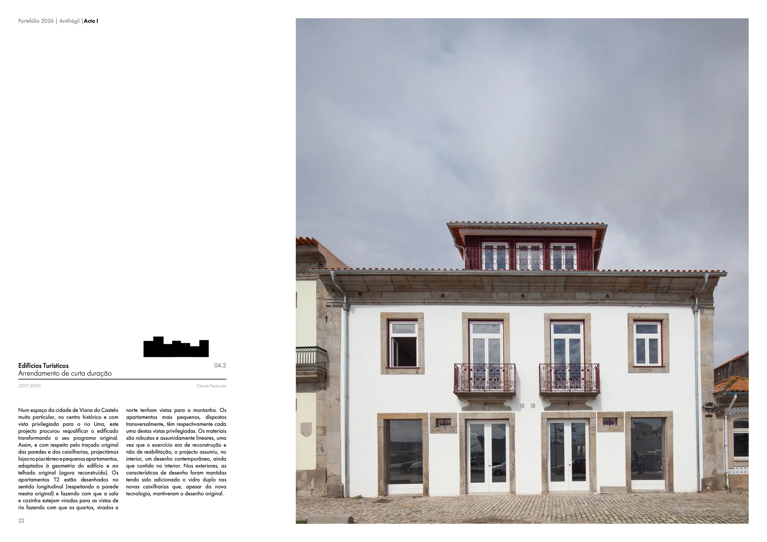 Prédio de três andares com fachada branca, janelas retangulares com moldura de pedra, duas pequenas varandas com grade de ferro na segunda andar, janelas no terceiro andar, telhado de telhas vermelhas, carro estacionado na rua de frente, céu nublado 