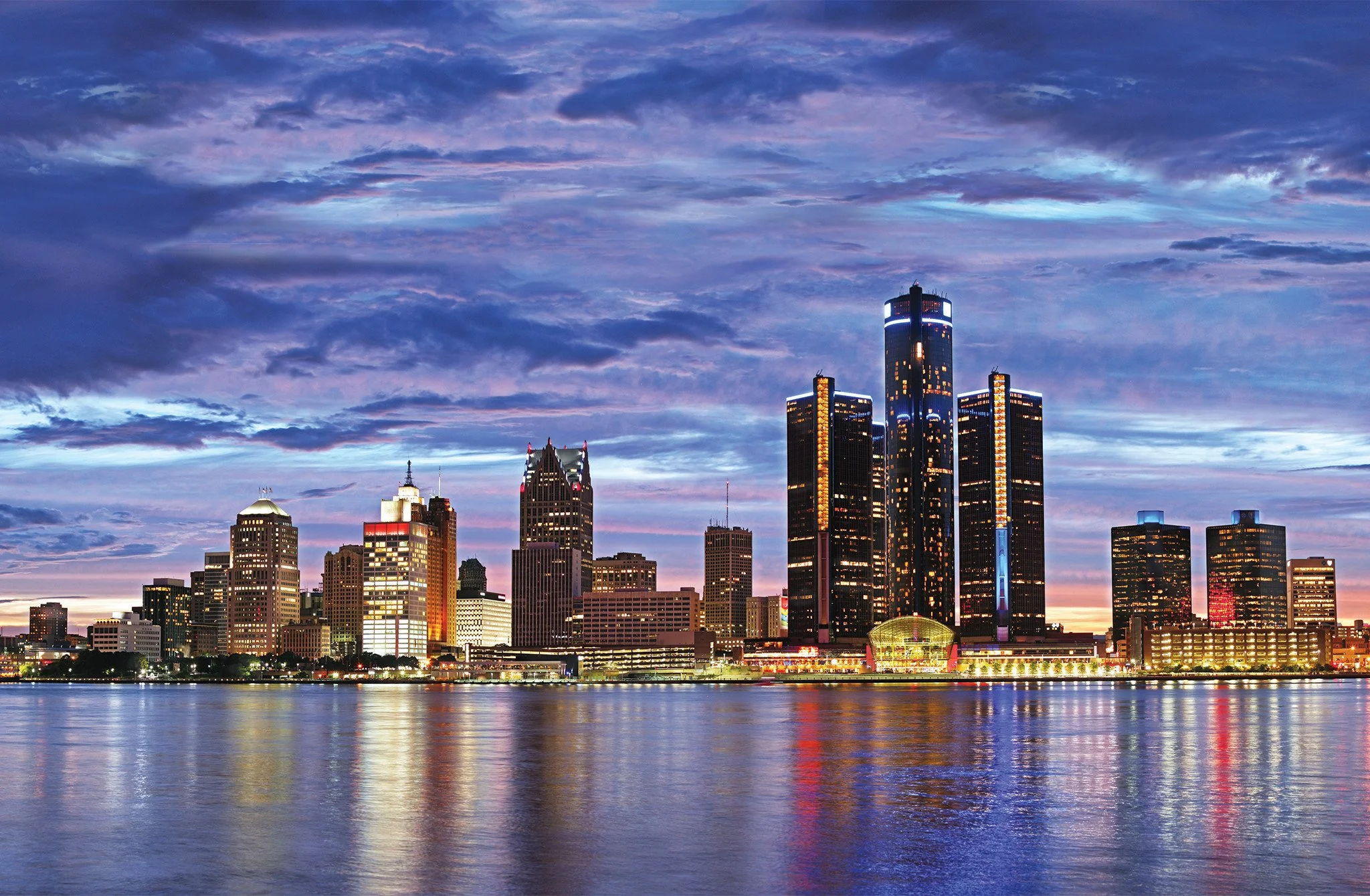 Skyscrapers and city skyline at dusk with reflections on water.