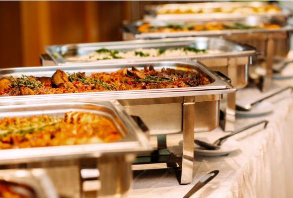 Buffet line with chafing dishes filled with various hot dishes