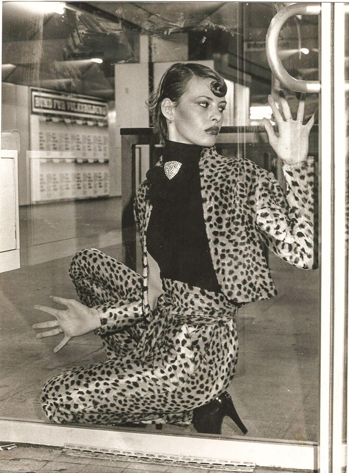 Frau in gepunktetem Leopardenmuster-Outfit in einem Schaufenster.