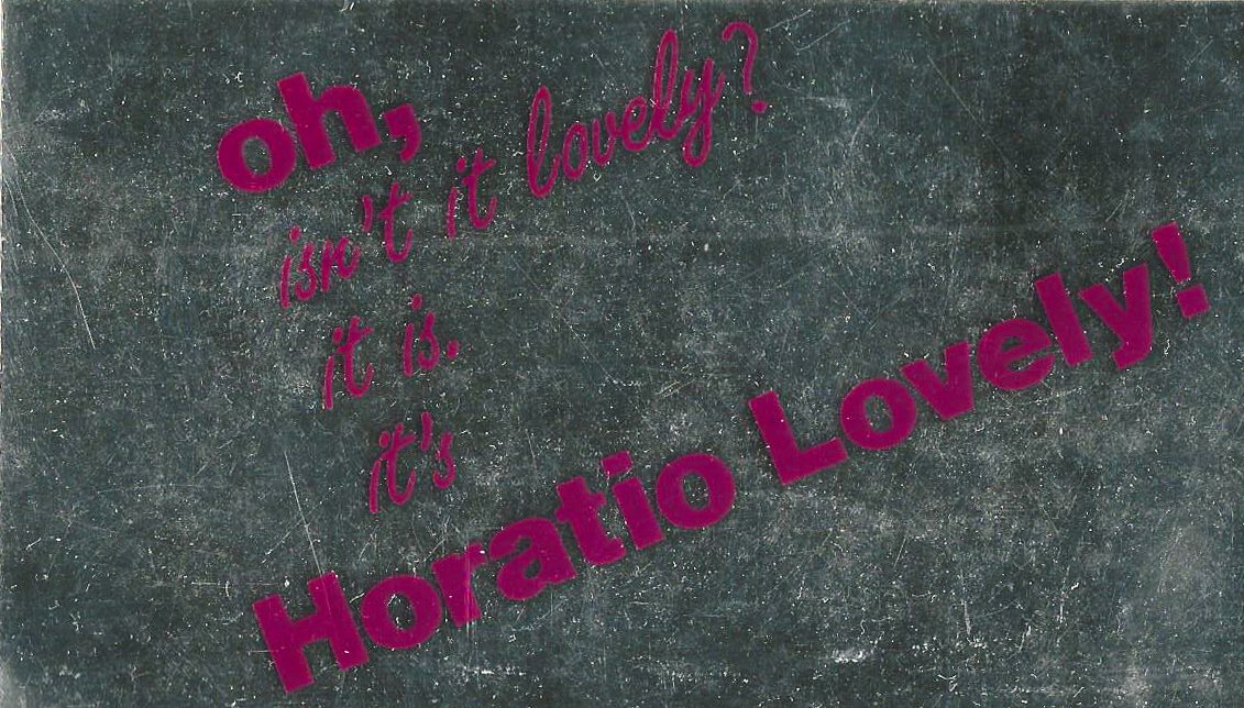 Text auf einem schwarzen, strukturierten Hintergrund: "oh, isn't it lovely? it is. it's Horatio Lovely!" in lila Schrift.