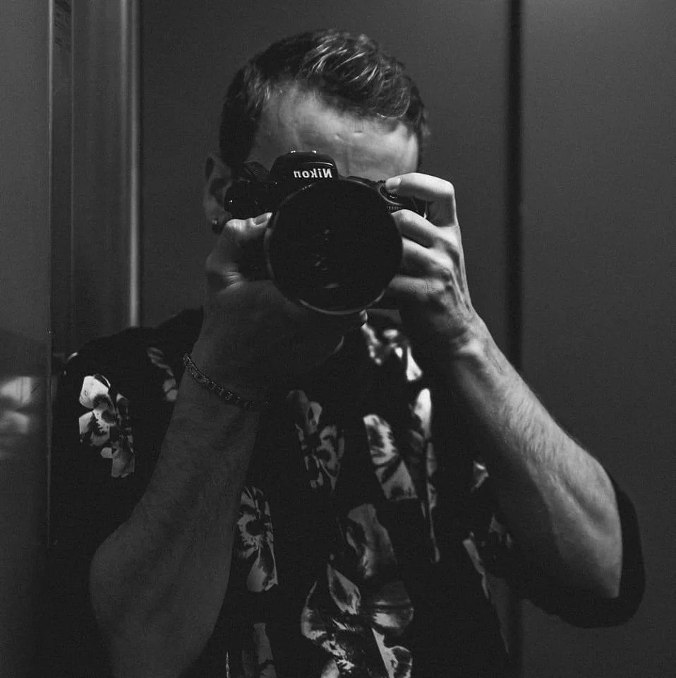 Persona scatta una foto con una macchina fotografica reflex in bianco e nero.