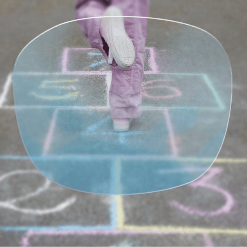 Child jumping on a hopscotch game drawn with chalk on pavement.