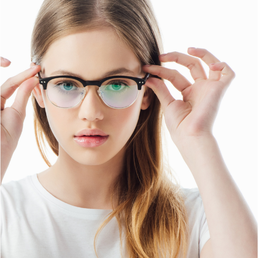 Young woman with long red hair wearing black glasses and a white shirt adjusting her glasses.