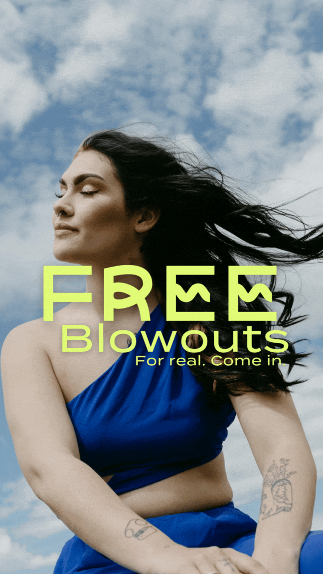 Woman with long dark hair wearing a blue outfit standing outdoors under a partly cloudy sky.