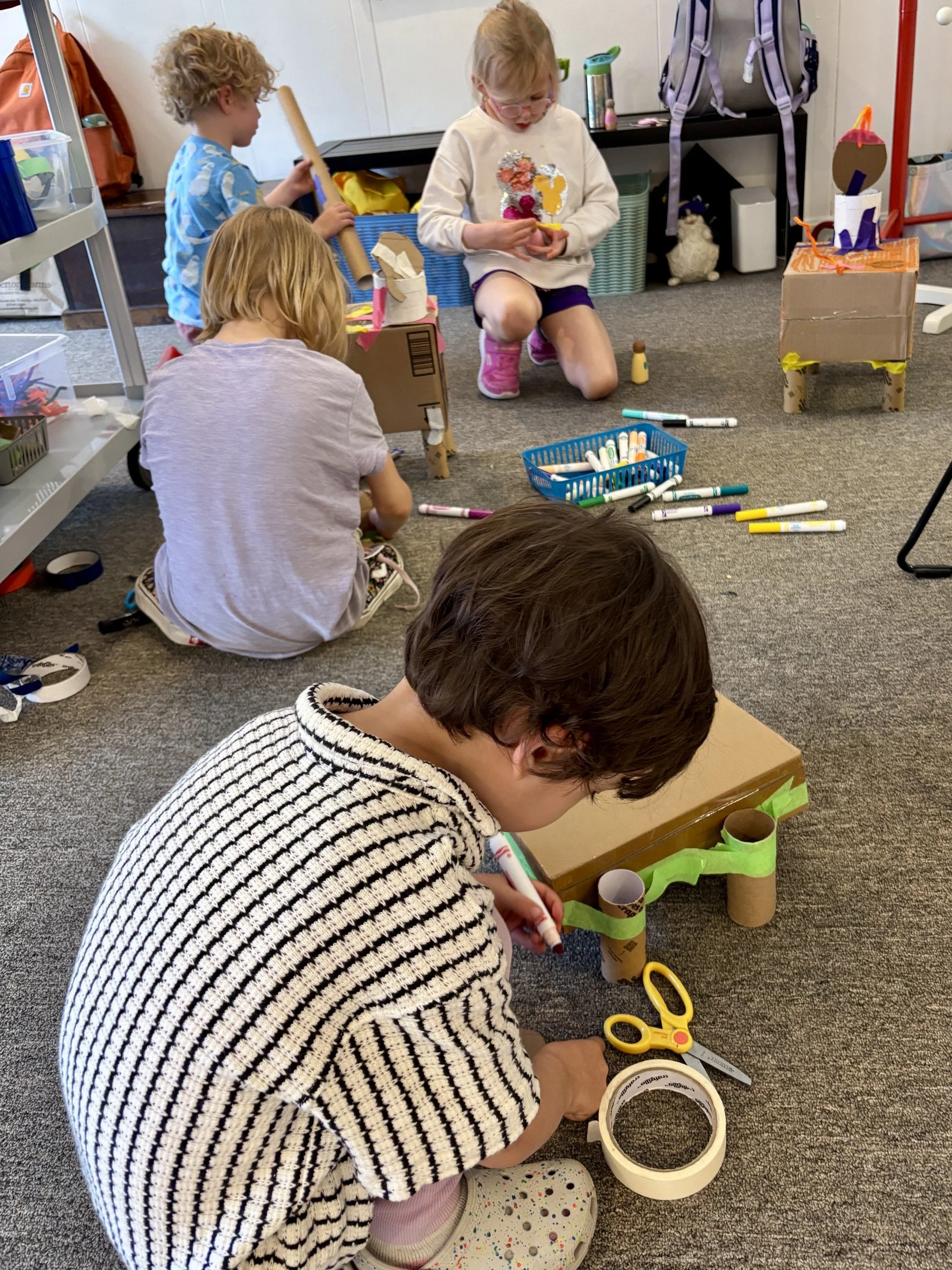 Children creating cardboard sculptures in art class