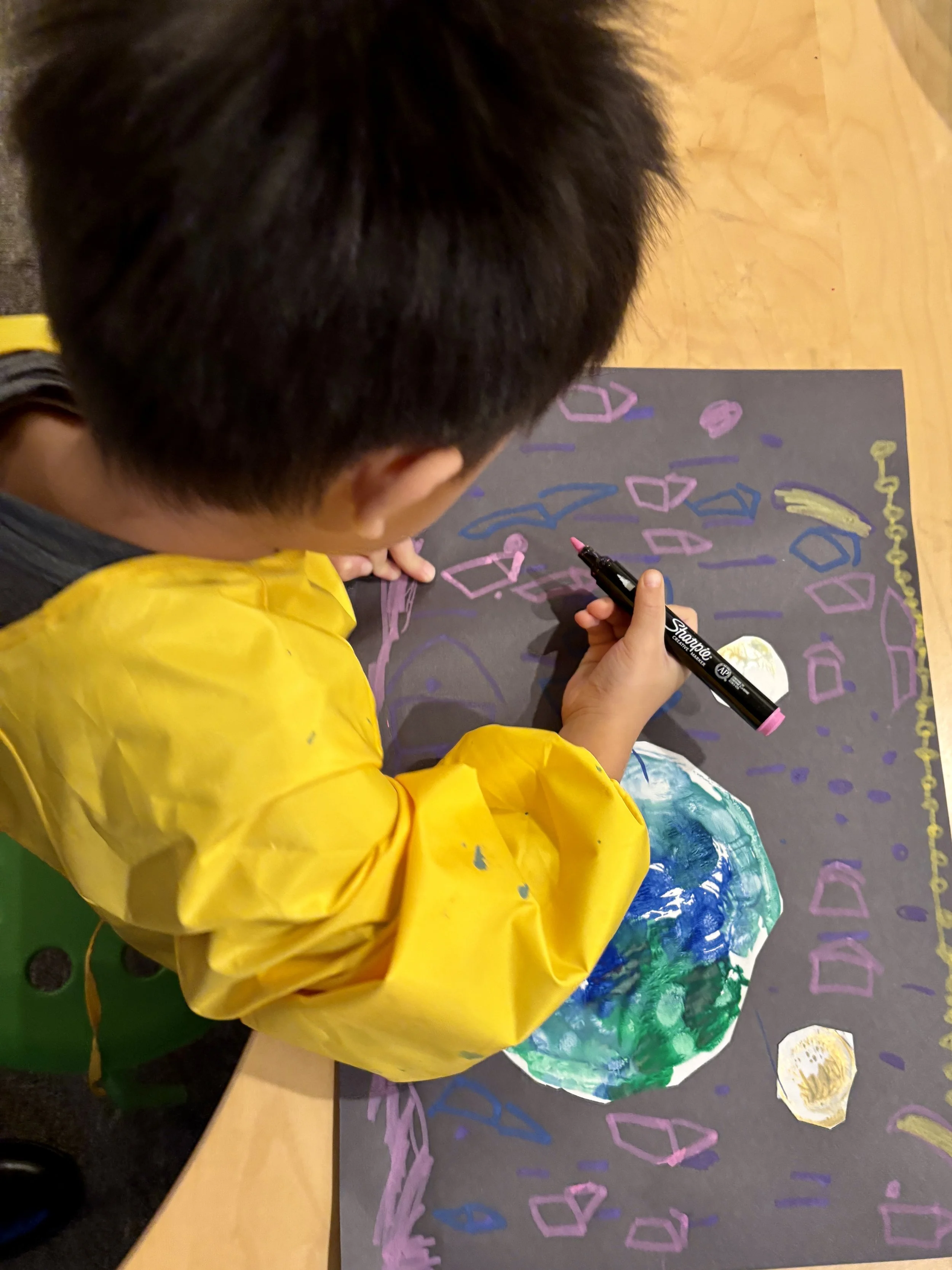 A child drawing planets and stars
