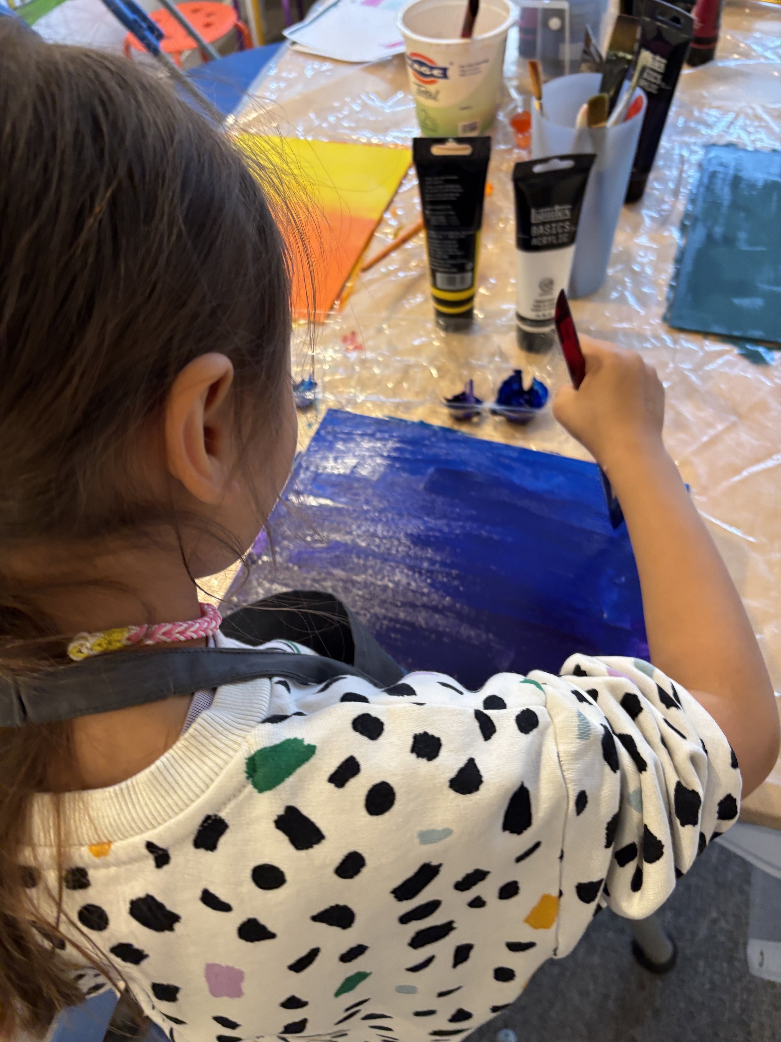 A child painting on canvas with acrylic color