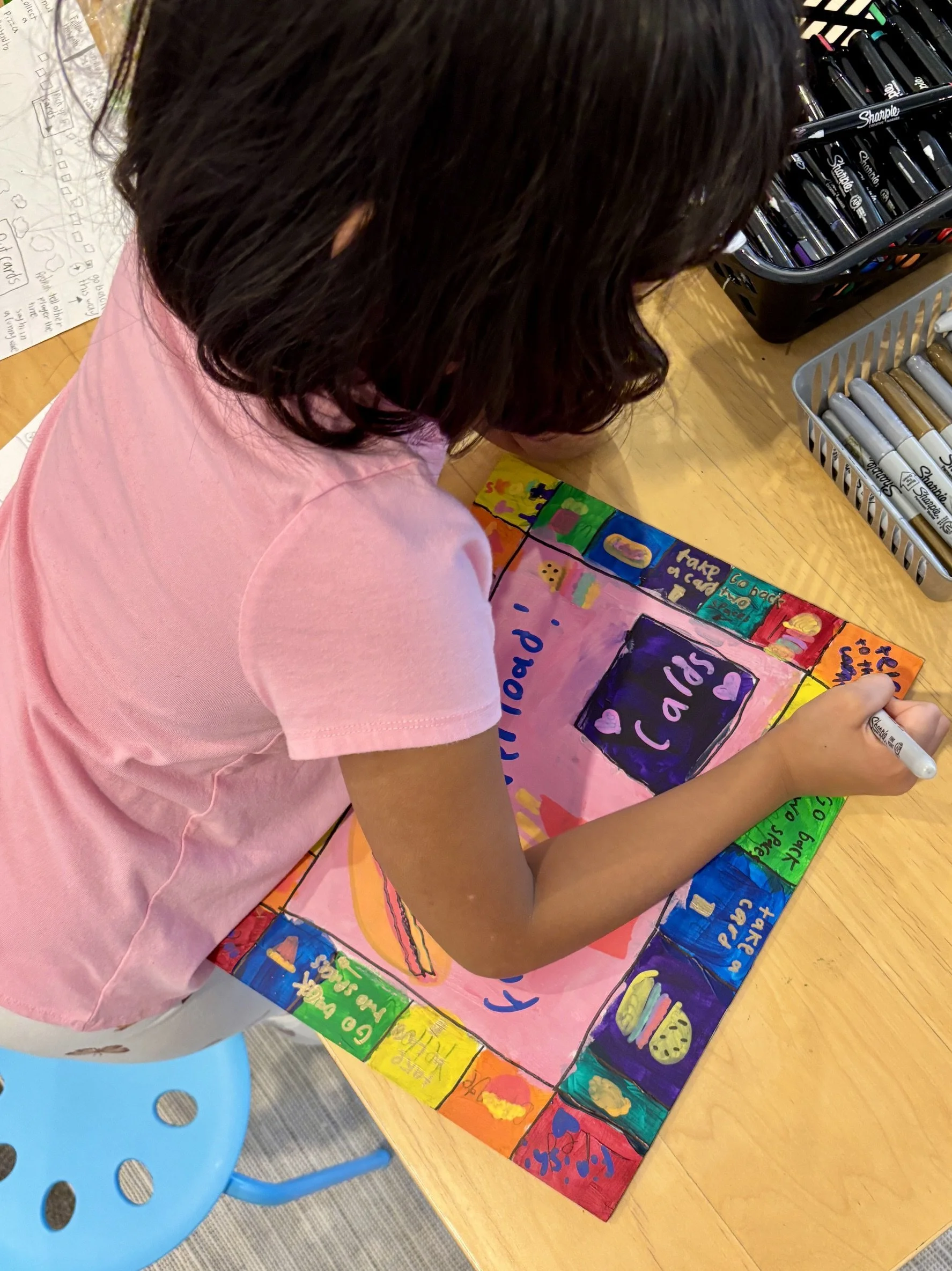 A child creating a board game in art class