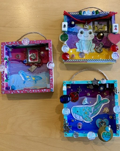 Mixed media shadow boxes created by children at Blue Mouse Gallery