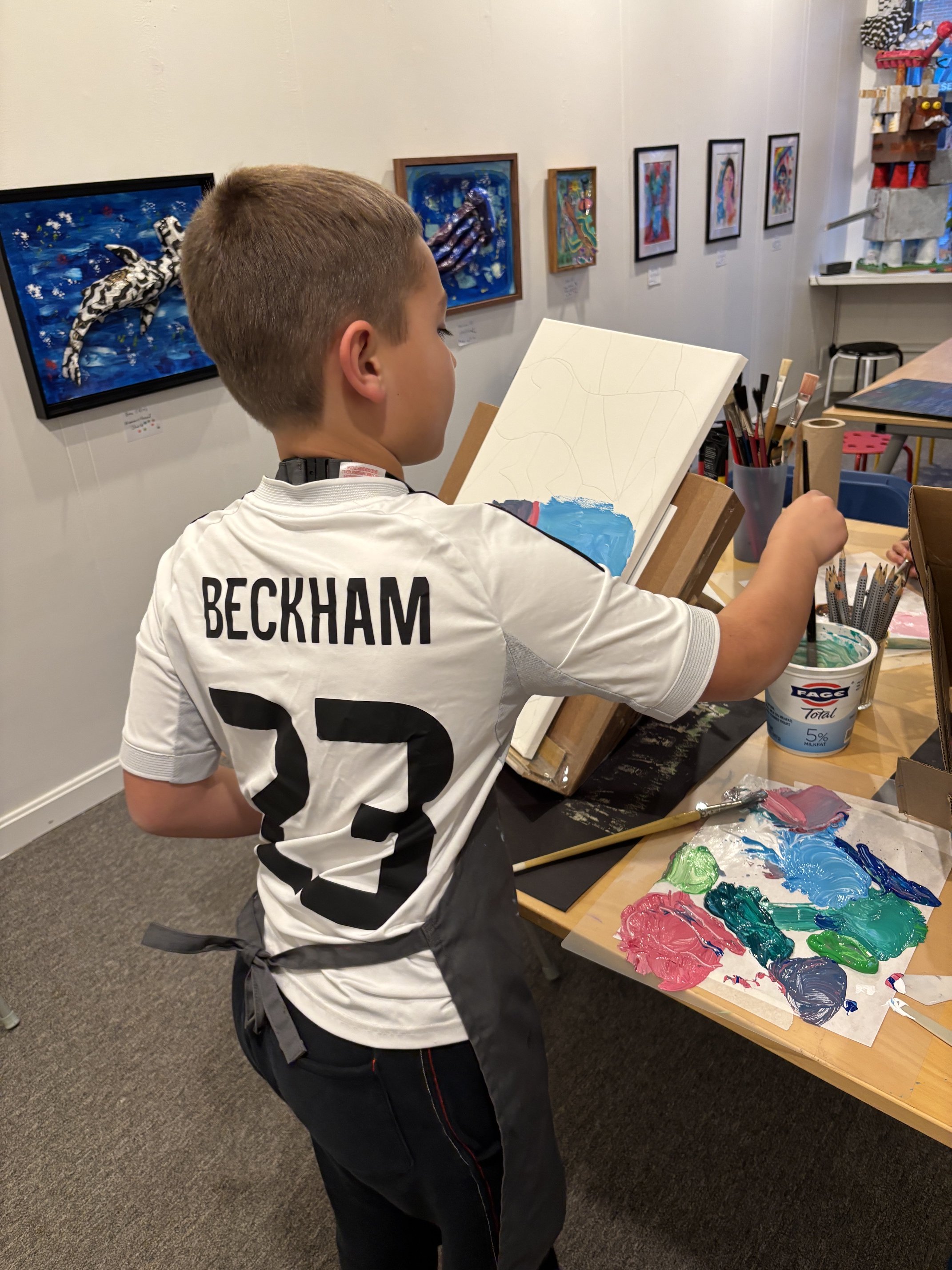 A child painting on canvas in art class