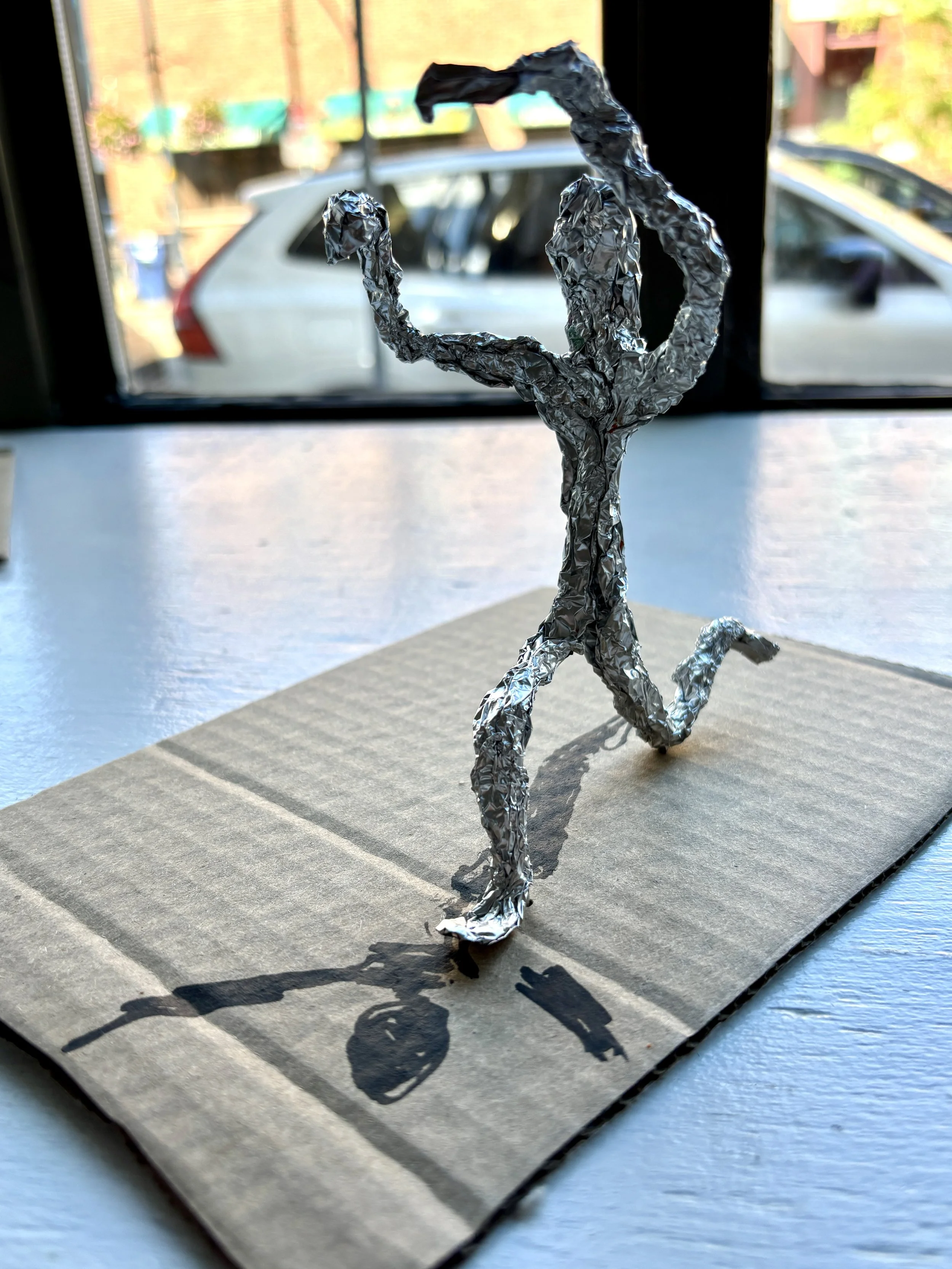 A tin foil sculpture of a dancing person