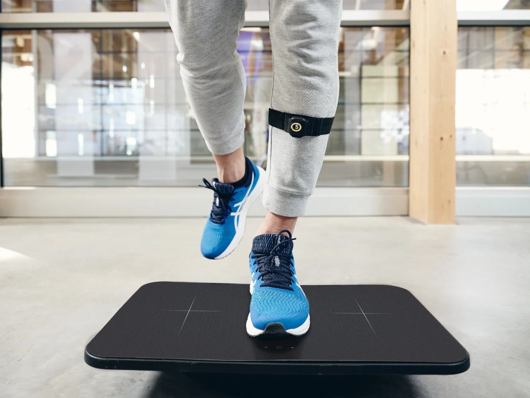 Primer plano de pies sobre la plataforma Euleria Lab con sensor en el tobillo durante ejercicio de control postural y equilibrio