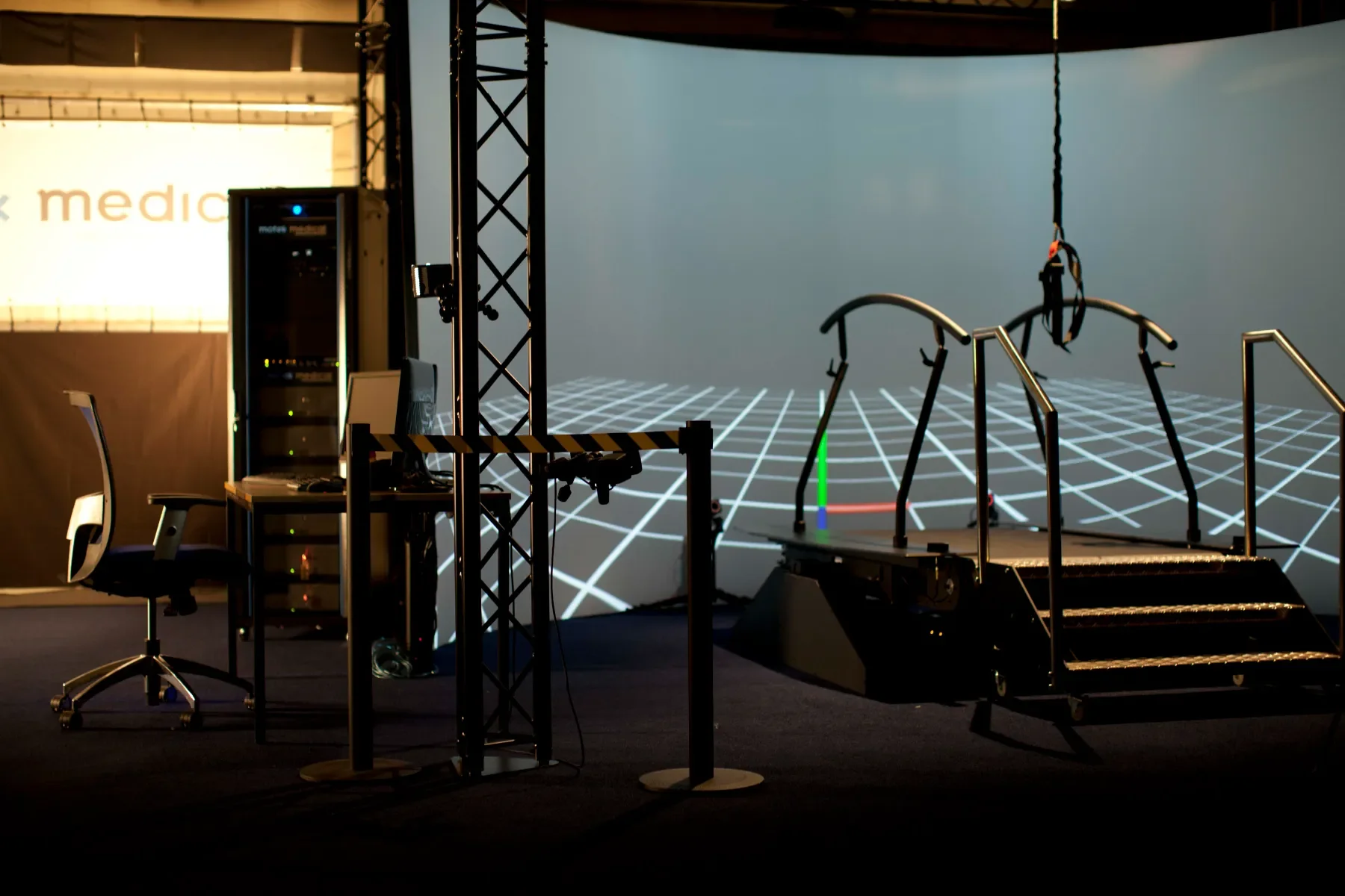 Laboratorio de marcha VR GRAIL con pasarela instrumentada, pantallas envolventes y puesto de trabajo clínico para análisis cinemático del paciente. Bayber distribuye Grail en España y Portugal