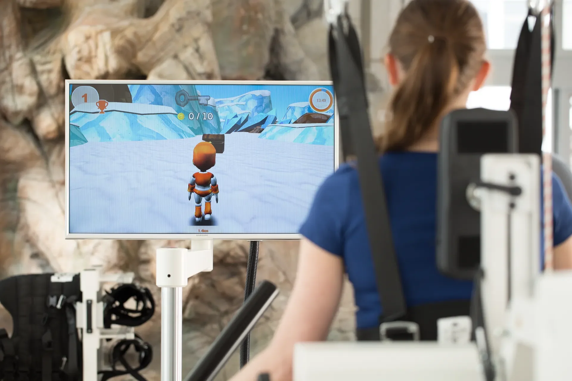 Paciente en Lokomat Pro realizando terapia de marcha robotizada con videojuego motivacional para rehabilitación neurológica. Bayber distribuye Lokomat en España y Portugal