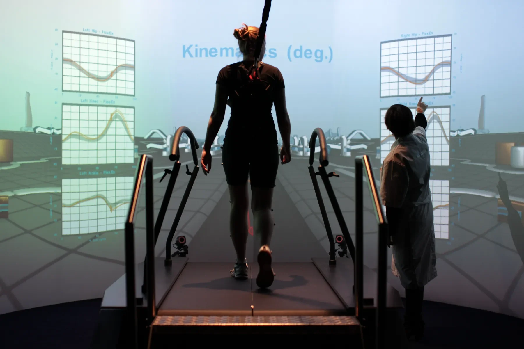 Paciente adulto caminando en GRAIL mientras el clínico revisa en pantalla el análisis cinemático de la marcha en laboratorio de marcha VR. Bayber distribuidor oficial España y Portugal