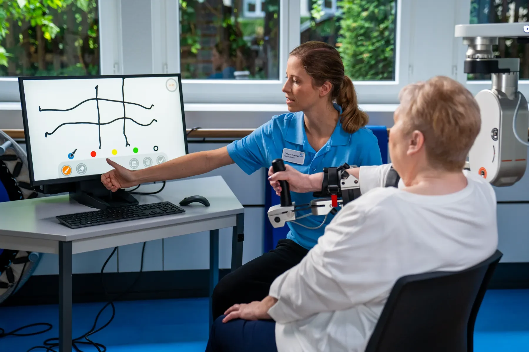 Paciente adulta en ArmeoSpring Pro trabajando movimientos asistidos de brazo en entorno motivacional de terapia de miembro superior. Bayber es el distribuidor oficial de Hocoma en España y Portugal