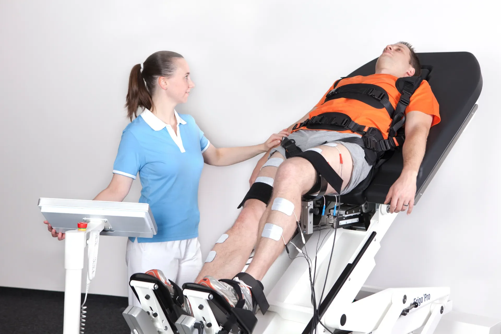 Paciente sujeto en posición supina sobre Erigo Pro durante fase inicial de movilización funcional con supervisión de fisioterapeuta. Bayber Health distribuidor oficial España y Portugal